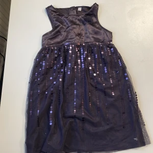 Lila paljettklänning - Fin och sparsamt använd paljettklänning.  Stl 128-134 Mycket sparsamt använd.  Från rök- och husdjursfri familj.