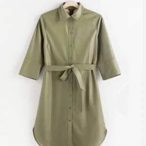 Grön Skjortklänning i läderimitation - Skjortklänning i läderimitation i jättefin skick. Denna skjortklänning är slutsålt idag, gick för 499 när jag köpte skjortan.  Passar superfint för dag och kvällstid.