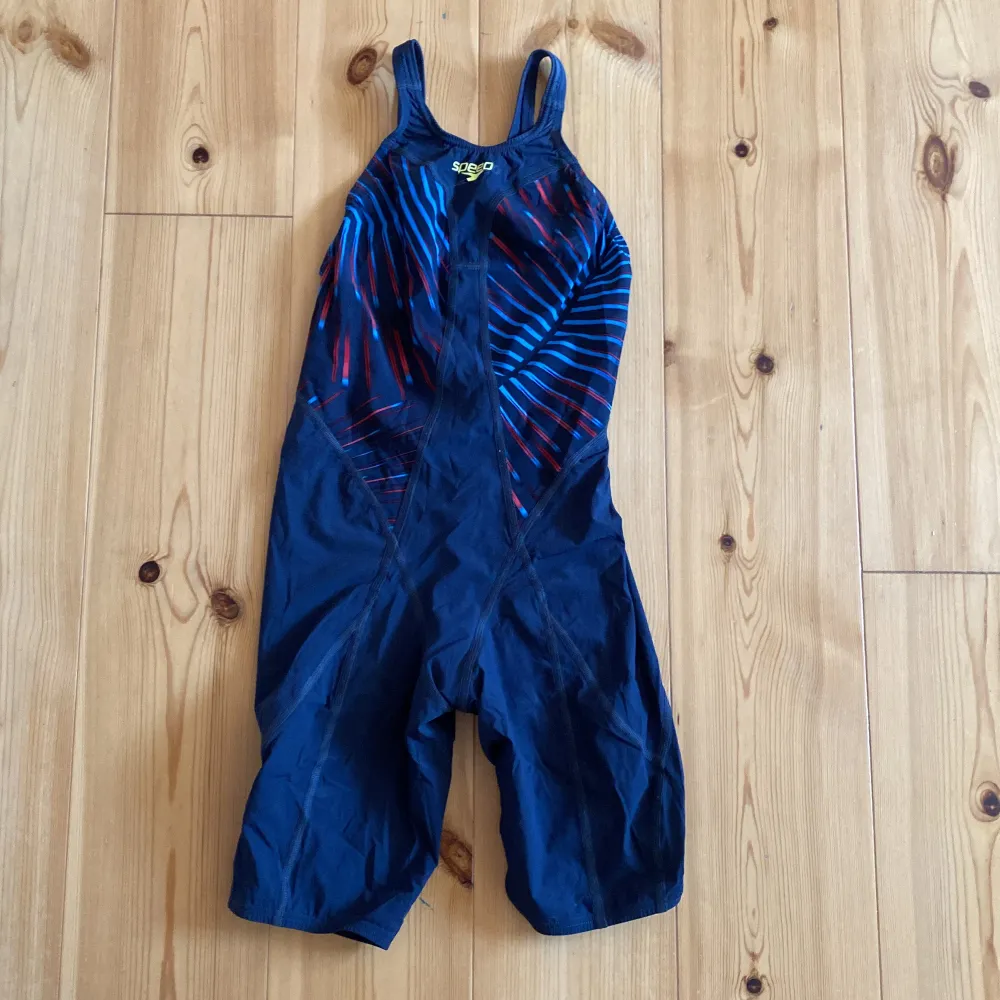 Snygg tävlingsbaddräkt från speedo. Står storlek ”SRJ13” men passar ordentligt tajt på mig som annars är 36. Märket har börjat lossna lite. Säljer då jag slutat simma och har för många. Villig att diskutera pris vid snabb affär eller köp av flera plagg.. Muu.
