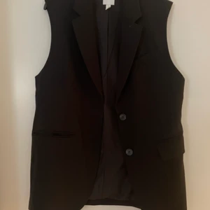 Ärmlös kavaj svart  - En fin stilren ärmlös kavaj från H&M  Använd en eller två gånger nyskick  Storlek S  Svart 