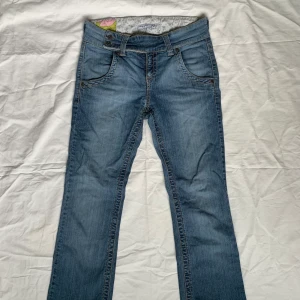 Lågmidjade jeans från 00-talet! - Så fina lågmidjade jeans med jättefin detalj på knäppningen där fram! Helt perfekta ;-; tyvärr något för stora för mig, vilket är varför jag säljer. Storlek 38 (tänk på att man ofta behöver ngt större strl på lågmidjade)! Jag är 166 cm lång.
