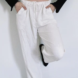 Vita linnebyxor med snörning - Fina linnebyxor i mjukt, luftigt material med snörning och fickor! Köpte dem förra sommaren men har tyvärr inte fått så mycket användning för dem, främst pga passform. Byxorna är lite för korta för mig, passar förmodligen perfekt på 160-170 beroende på önskad stil. Är själv 172cm. Jätte bra skick och är knappt genomskinliga endast lite i vissa ljus. Byxorna är slutsålda. Orginalpris 370kr, som sagt nästan helt oanvända. Fråga gärna om fler bilder!💕