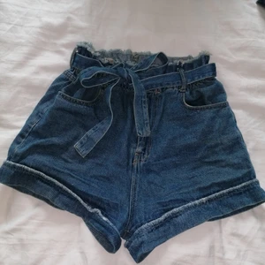Shorts från Asos med knyte  - Supersköna högmidjade shorts från Asos som passar xs-s beroende på om man vill ha paperbag-fit eller mer figurnära. Stretch och knyte i midjan. Lagom korta, fin tvätt, mjukt material. Bra skick! 