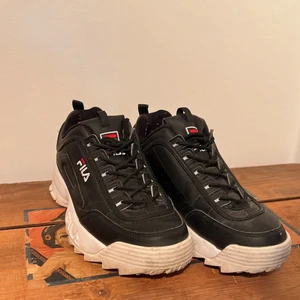 Fila skor i storlek 42 - Ett par svart/vita nästan oanvända Fila sneakers med reflex 
