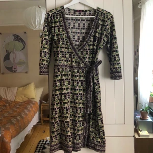 Omlott-klänning - Omlottklänning från indiska i stretchigt material. Storlek S, men passar även mig som har L. 