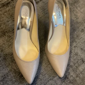Michael Kors pumps - Michael kors pumps storlek 39  i ljusgrått med svart klack. Använda 1ggr. I nyskick 