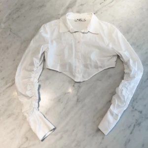 Kort vit skjorta med scrunch  - Kort vit skjorta med ”scrunch” på ärmarna. 