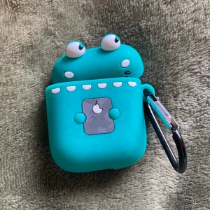 airpodskal  - ett airpodskal som jag tror ska vara en krokodil som håller en iPad ☺️ Använder inte detta skal och inte mina airpods heller för den delen ! så säljer detta för 50kr +frakt ❣️ tar endast Swish! har av dig vid intresse 🫶🏻