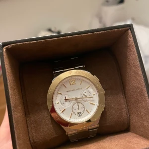 Michael Kors, klocka - Säljer en klocka i guld & silver från Michael Kors. Nypris ca 3000 kr, mitt pris 400 kr eller högstbjudande. 