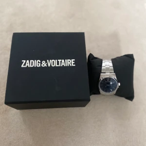 Zadig & voltaire klocka  - Säljer min fina klocka ifrån Zadig & Voltaire då jag fick den i present och jag tyvärr inte använder silver smycken. Finns inte kvar i sortimentet längre. Justerbart band. Den är aldrig använd så den är i nyskick. Nypris är 2200kr. Pris kan diskuteras.