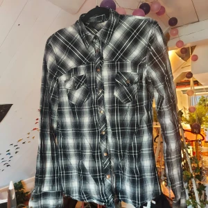 Glittrig svart och vit rutig skjorta - Fin rutig skjorta i bra skick! Köpt second hand och endast använd fåtal gånger. Knapparna är lite slitna men det är inget man märker av💛  Står ej för frakt🧡