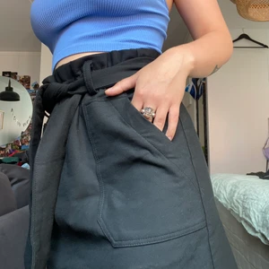 Svart kjol - Skön, kjol i tjockare tyg med knytning i midjan. Snyggt att byta ut knytningen till ett skärp också! Går även bra att använda utan nåt i midjan pga resår FICKOR! Aldrig använd, endast provad