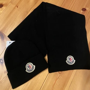 Moncler mössa och halsduk  - Säljer denna fina mössan och halsduken. Vet ej om dom är äkta där av priset. Aldrig använd 