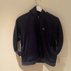 Lacoste Half zip hoodie - Säljer min urvuxna Lacoste Half zip Hoodie. Fint skick finns inga märken eller fläckar!  Färg: mörk blå   Kan gå ner i pris vid snabb