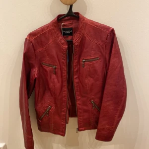 Röd skinnjacka  - Röd jacka i skinnimitation i mycket bra skick, säljer då den inte passade. Köpt från Sellpy 