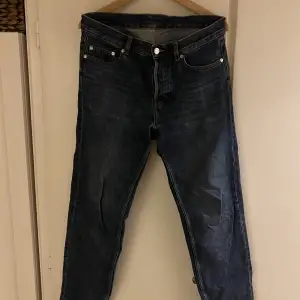 Mörkblå jeans från Arket i smått croppad stil. (På mig som är 183cm slutar de precis innan en låg sko.) storlek 30 men sitter som 31. Använt skick med lite slitning i grenen. 