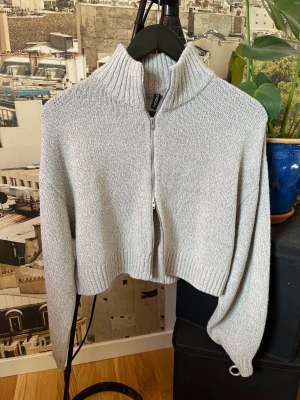 Kofta - Ljusgrå stickad kofta från HM med dragkedja. Mycket bra skick men kommer inte till användning.