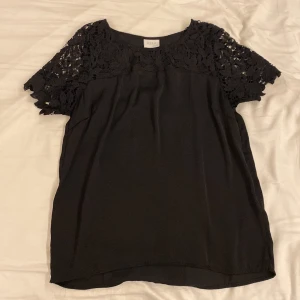 Svart blus - En svart lite finare blus, med väldigt skönt material, lite spetsaktig uppe vid ärmarna och över bysten. Kan vara lite tajtare över axlarna och vid bröstet om man har lite större bh storlek. Bara använd ett fåtal gånger och är inte använd på något år😊