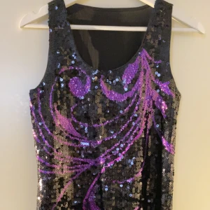 Glittrig klänning  - En svartlilla fest klänning, har en bra skick