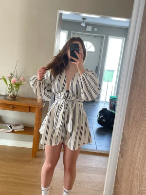 Randig Byxdress  - Byxdress i randigt typ köpt på ASOS i strl 38. Knäppe på framsidan samt snörning. Puffiga armar och kurvig passform. 