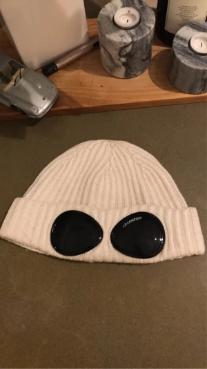 C.P Mössa - Säljer min vita C.P mössa. Mössan är sparsamt använd inte smutsig eller repig och nytvättad. Säljer den då jag inte längre använder den. Den är äkta och i väldigt bra skick typ 8,5/10