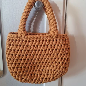 Liten virkad handväska  - Liten virkad handväska i återvunnet material efter gamla t-shirtar. Perfekt till mobilen och läppglanset. 