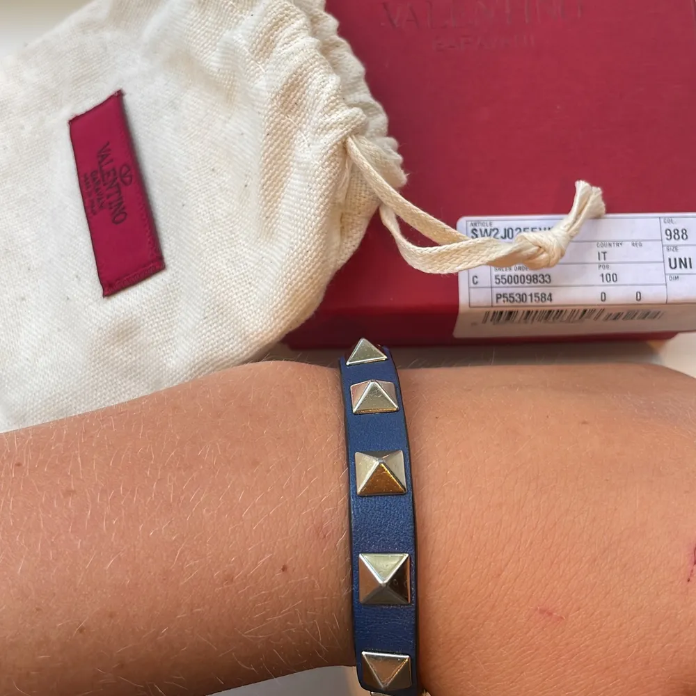 Säljer mitt fina valentino armband i marinblå färg med guldiga nitar💗💗💗köpt för 2250 på deras hemsida🥰box, dustbag, Äktighetsbevis medföljer såklart.💗. Accessoarer.