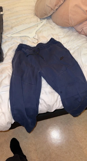 Nike tech mjukisbyxor blå  - Som ni ser på bilden så är dom inte bästa skick där bak är det något konstigt vet ej om det går bort 