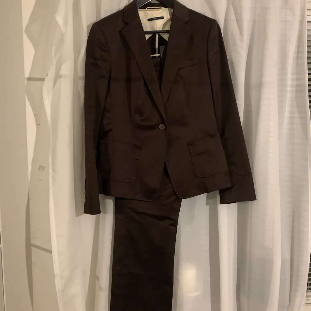Mörkbrun kostym i dam från  hugo boss. Passar 36/38. Köpt second hand för 900kr. Inga tecken på användning, jag har aldrig använt den då den inte passar. Pris kan diskuteras vid snabb affär! . Kostymer.