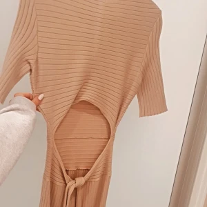 Supersnygg ribbad klänning med öppen rygg - Oanvänd klänning, figursydd, öppen rygg och ribbad. Säljer då den inte kommit till användning. 🤎