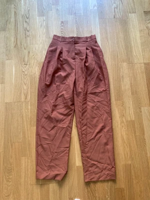 Bruna kostymbyxor  - Superfina dressbyxor! Dom passar tyvärr inte mig så endast provat. Skulle säga dom är ganska stora i storleken - dom är båda för långa i benen och lite för stor rundt midjan för mig, så passar kanske bättre för en M.