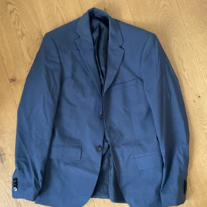Blå Blazer  - Änvändt endast en gång. Blå kostymjacka med axelvaddar 