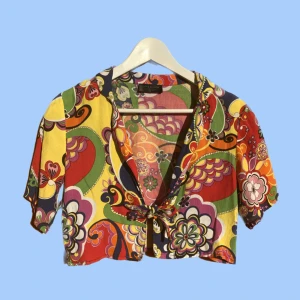 Croppad knytblus - Psykadeliskt mönstrad knytblus från zara i syntetiskt material. Materialet är inte stretchigt. Tröjan är i storlek S men skulle också passa XS. Om du har några frågor eller vill se fler  bilder är det bara att skicka iväg ett meddelande:)