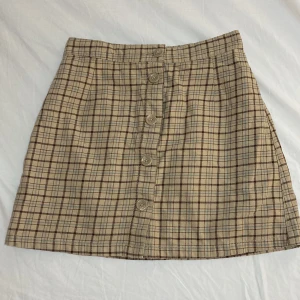 Rutig kjol från Monki, 38 - Beige, rutig kjol från Monki i storlek 38. Aldrig använd.