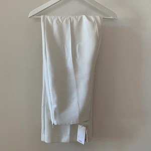 Vita kostymbyxor  - Vita kostymbyxor i nyskick. Bara testade! Säljer dem vidare då dem inte passade med kavajen jag skulle ha på min student🥺 Jag är egentligen en S/M men dessa är i L då jag är 180 och är lite bredare runt lår och höft. Taggen sitter fortfarande på<3 köpte dem för 599 så ge ett förslag på pris annars (skriv för hur de sitter på)