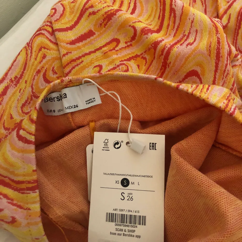 En skitsnygg klänning från Bershka med gult/orange/rött/rosa mönster!!! Halterneck med knyt i ryggen, strl S, aldrig använd med lappar kvar 🧡. Klänningar.