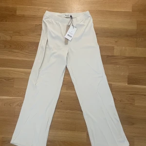 Ribbade byxor - Krämvita, ribbade byxor från Na-kd. Aldrig använda, lappen kvar.