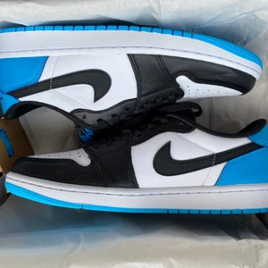 Jordan 1 Low OG Dark Powder Blue ”UNC” - Jordan 1 Lows i storlek 43. Skorna är helt oanvända och köpta från SNKRS sidan. Blåa skosnören tillkommer.  Färgen är ”Dark Powder Blue”