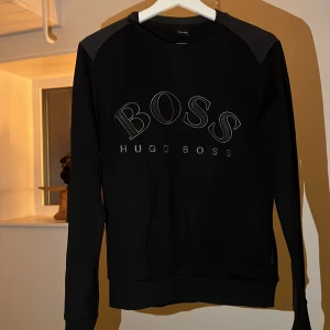 Hugo Boss tröja i skönt material  - Detta är ett plagg från Hugo Boss. Tröjan är använd men i bra skick 8/10. Inga märken eller fläckar. Köpt på johnells i Uppsala för 1799kr runt 1,5 år sedan men är numera för liten, tröjan är i strlk XS men sitter som en S. Mvh isac 