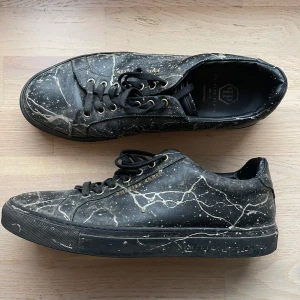 Philipp Plein sneakers med guldstänk - Svarta skor från Philipp plein med guld detaljer. Nypris 5000kr, storlek 44. Använda men går att putsas upp