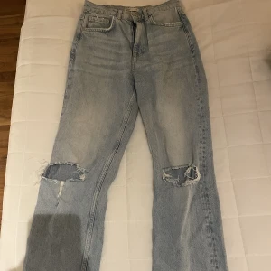Gina tricot jeans - Jeans med hål ifrån Gina, knappt använda men sitter jättesnyggt❤️ de sitter mid-waist på mig