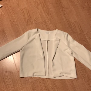 Vit blus - En vit blus med en knapp som håller ihop den.