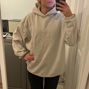 Hoodie benvit - Benvit hoodie. Lite hårdare i materialet. Resår i armarna. Kan dra åt nertill! Oversized.