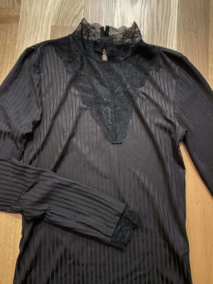 En svart blus - En svart blus med krage av spets