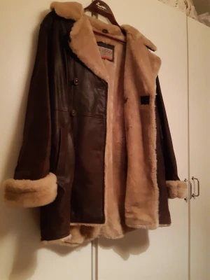 Vinterjackor  - Tre stycken vinterkappor. Bild nr 1: skinnjacka med fårskinn, storlek 40. 600kr. Bild nr 2 fuskpäls storlek 40 600kr, ullkappa marinblå storlek 38-40 500kr. 