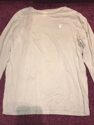 Ralph lauren tröja storlek S - Tröjan har två små blekningsfläckar och därför ett väldigt lågt pris. Den är dock jätteskön att ha på sig under en tjock jacka där man inte vill ha kofta. Tröjan är äkta. Färgen är lite grå beige aktig.