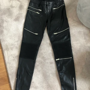 Byxor  - Byxor i fejk läder från ZARA, storlek 34. Ena flärpen där man fäster skärpet är ”av” i övrigt fint skick. 