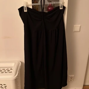 Medllång svart klänning  - Svart medellång klänning från H&M med snörning runt halsen.