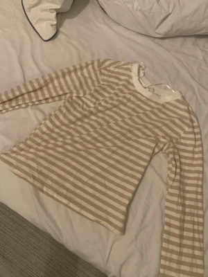 Gullig tröja från hm - En tajt tröja från hm, aldrig använd. Passar inte riktigt i beiget, Stl S men passar även Xs och M beroende på hur man vill ha den:)