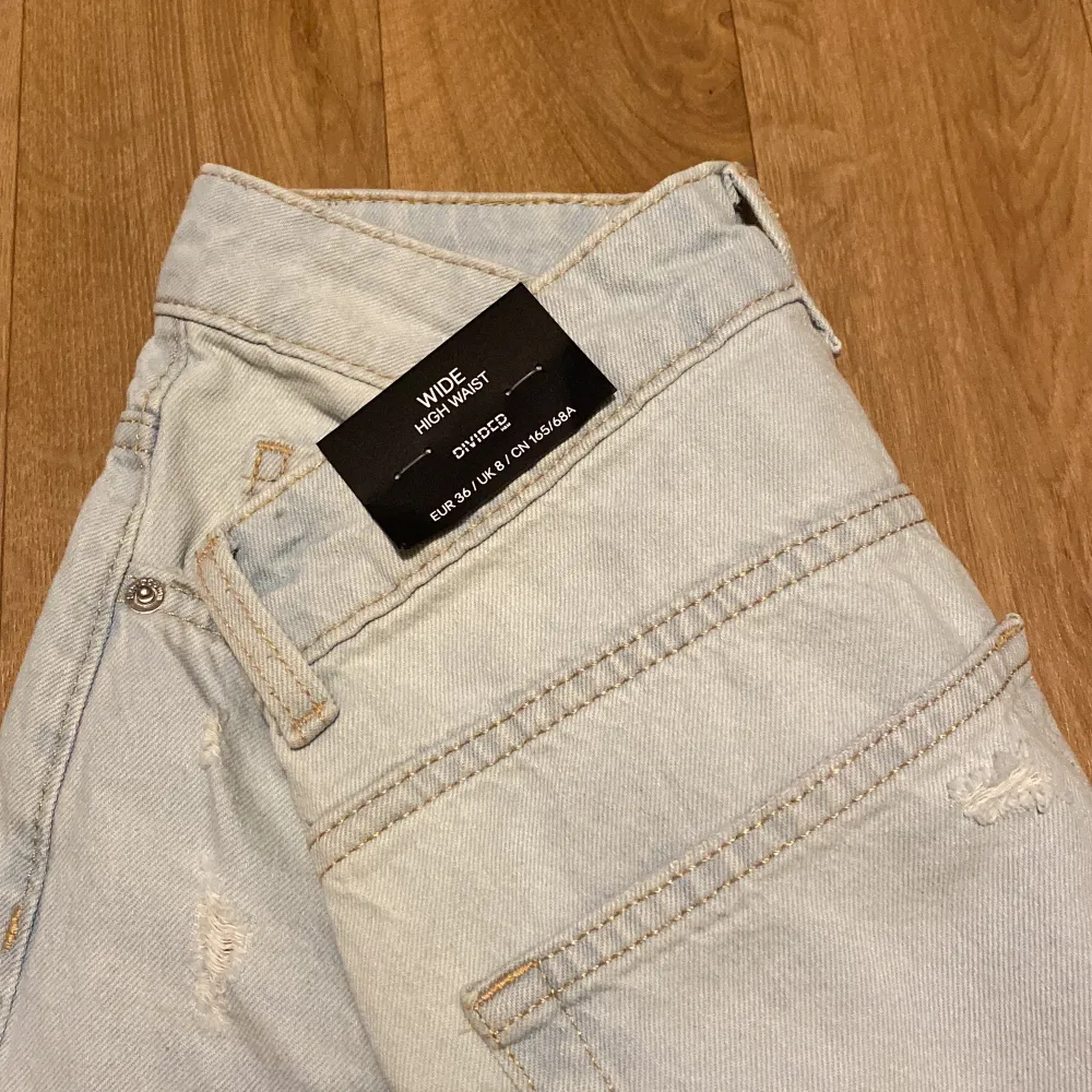 Ljusblå wide High Waist jeans med hål på knäna. Helt nya och är endast provade. . Jeans & Byxor.